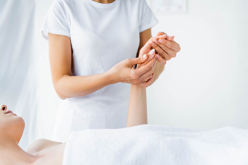 cropped view of masseur doing hand massage